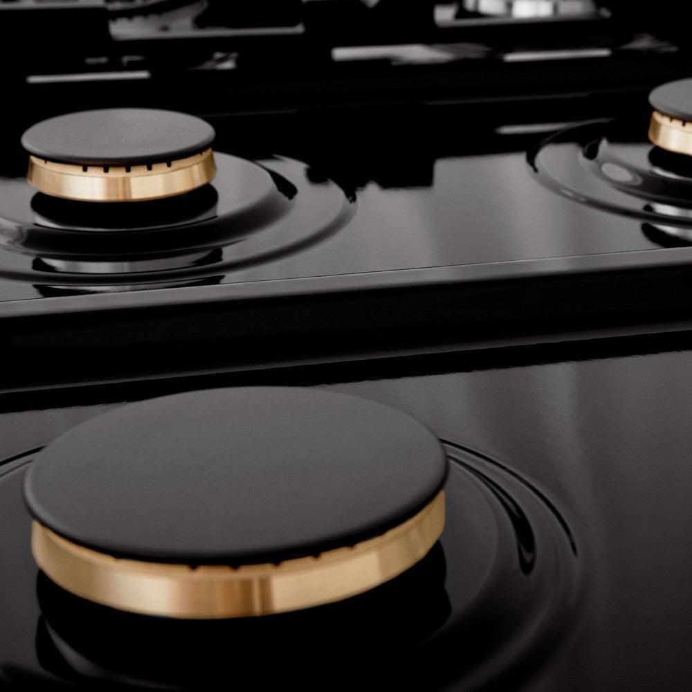 Close up of brass burners without grates on black porcelain cooktop.